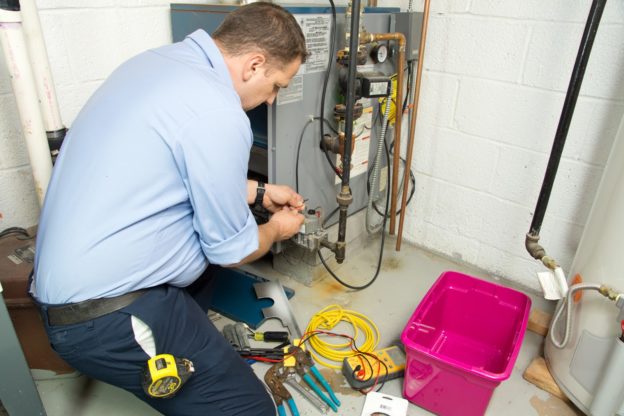 A technician performing maintenance on a heating system.