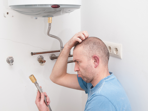 A confused man trying to figure out how to repair a boiler