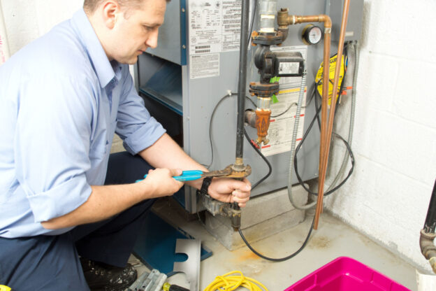 A technician performing a service on a furnace.